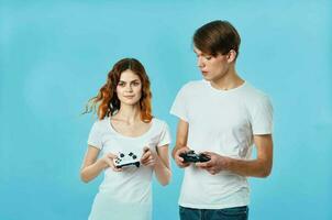 young couple t-shirt with joysticks in hands video games technology blue background photo