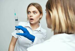 hembra médico en azul guantes inyección jeringuilla comunicación paciente foto