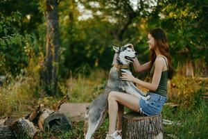 mujer y su fornido perro felizmente jugando al aire libre en el parque entre el arboles sonrisa con dientes en el otoño caminar con su mascota foto