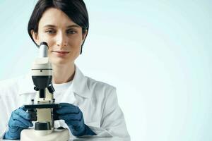 Woman in white coat laboratory science microscope analyzes photo