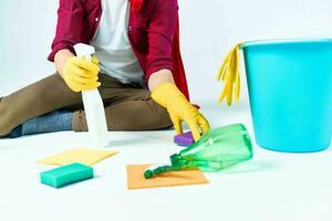 A man in a red raincoat sitting at home washing the floors providing services detergent accessories photo