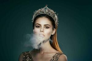 woman with a crown on her head smoke from the mouth Glamor luxury dark background photo