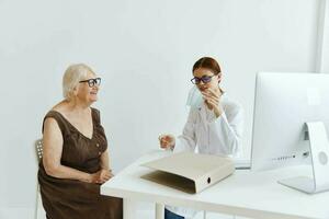 doctores en el médico oficina hablando a un mayor mujer salud cuidado foto