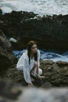 Woman in white dress rocks sea nature photo