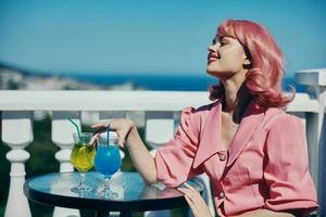 portrait of beautiful woman enjoying a colorful cocktail hotel terrace unaltered photo