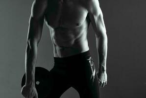 man with pumped up abs exercises motivation dark background photo