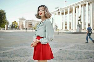 alegre mujer en rojo falda al aire libre Moda caminar al aire libre foto