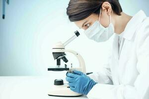 laboratory assistant looking through a microscope science research technology experiment photo