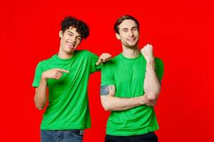 Two cheerful friends in green t-shirts are standing next to each other photo