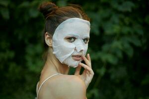 Portrait of a girl bare shoulders back view face mask cosmetology photo