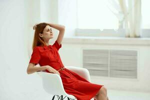 beautiful woman in red dress sitting on a chair elegant style photo