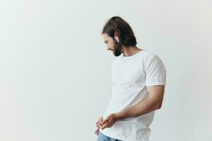 Stylish man in a white t-shirt with wireless headphones in his ears having fun listening to music smile on a white background lifestyle photo