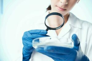 woman scientist looking through a magnifying glass research biology photo