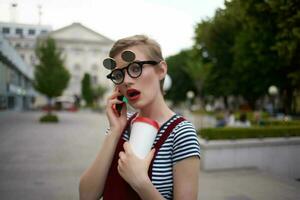 pretty woman with glasses talking on the phone on the street lifestyle photo