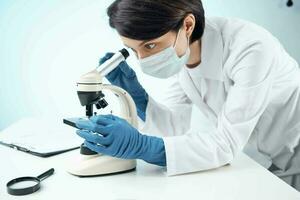 laboratory assistant wearing a medical mask looking through a microscope Professional research experiment photo