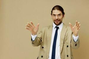 handsome man in a suit with a tie posing beige background photo