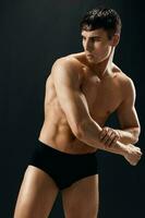 sporty man with naked body in black panties photo