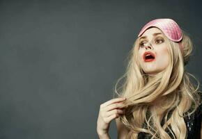 emotional blonde with a pink sleep mask on her head bright makeup Copy Space photo