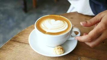 una taza de café tardío con un diseño en forma de flor en la parte superior del café video