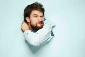 Emotional man peeks out from behind the wall of a career office work official photo