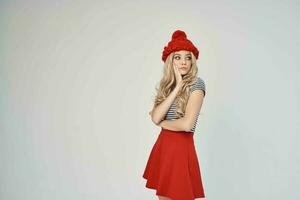 blonde in fashionable clothes Red Hat light background Lifestyle photo