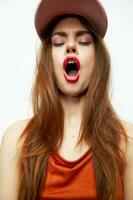Emotional woman in a cap Open mouth closed eyes charm and luxury red lips photo
