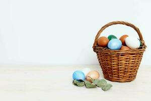Easter eggs in a basket on a light background and a church holiday photo