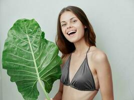 alegre mujer en un traje de baño estudio verde hoja exótico foto