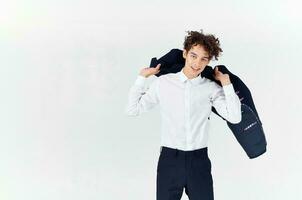 teenager in classic suit with jacket in hand and light background cropped view of pants photo