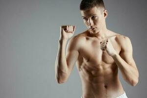 athlete with pumped up torso boxing on gray background cropped view of muscles photo