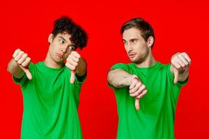 Cheerful friends in green t-shirts gesturing with hands isolated background photo