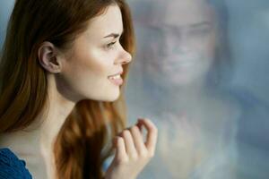 pretty woman sitting near the window with a blue plaid smile at home photo