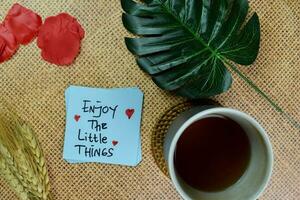 Enjoy The Little Things write on sticky notes isolated on Wooden Table. photo