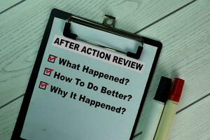 After Action Review and supported by additional services write on a paperwork isolated on Wooden Table. photo