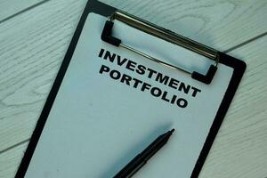 Investment Portfolio write on a paperwork isolated on Wooden Table. photo