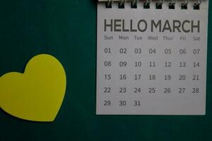 Top view Hello March text on a Calendar isolated on office desk photo