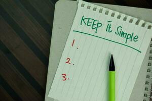 Keep it Simple write on sticky notes isolated on Wooden Table. photo