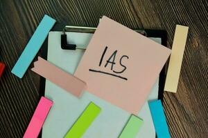 IAS write on sticky notes isolated on Wooden Table. photo