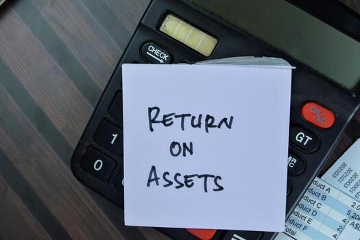 Concept of Return on Assets write on sticky notes with calculator isolated on Wooden Table. photo