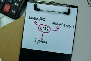 Concept of LMS - Learning Management System write on paperwork isolated on Wooden Table. photo