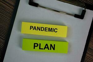 Pandemic Plan write on sticky notes isolated on Wooden Table. photo