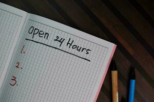 Open 24 Hours write on a book and supported by additional services isolated on Wooden Table. photo