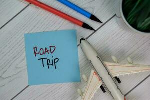 Road Trip write on sticky notes isolated on Wooden Table. photo