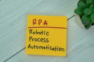 Concept of RPA - Robotic Process Automatisation write on sticky notes isolated on Wooden Table. photo