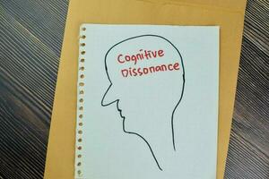 Concept of Cognitive Dissonance write on a paper book isolated on Wooden Table. photo