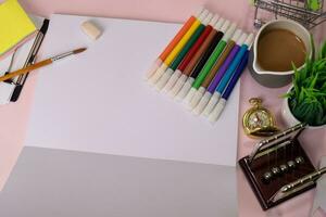 Top view of the open notebook with a marker drawing on a pink table, preparing to do homework. Drawing Working Desk Concept photo