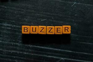 Buzzer on wooden cubes. On table background photo