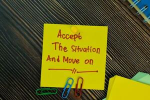 Accept the situation and move on write on sticky notes isolated on Wooden Table. Motivation concept photo