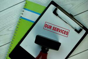 Red Handle Rubber Stamper and Our Services text isolated on the table. photo