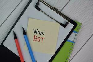 Virus Bot write on sticky notes isolated on Wooden Table. photo